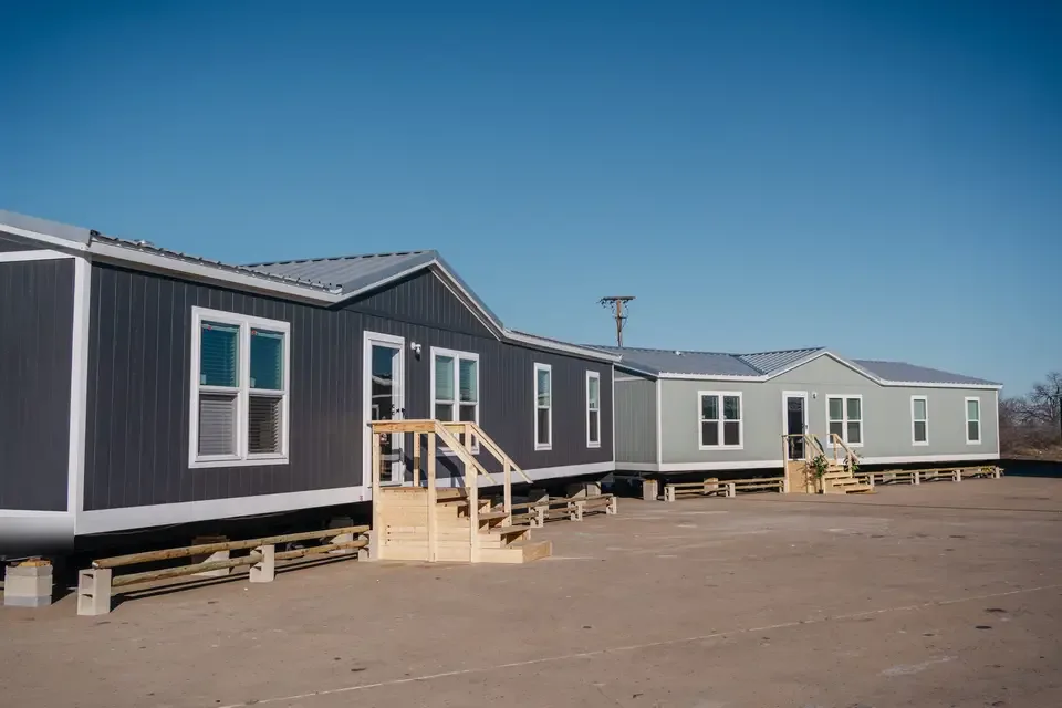 Crew housing units with wood entry steps, set and ready on a Texas yard